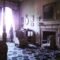 curtains sunlight depressed looking person standing in an old room